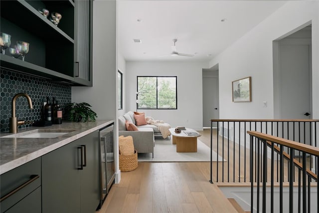 7809 Hardy Dr, Austin, TX 78757 - kitchen with wine cooler, decorative backsplash, light stone countertops, light wood-style flooring, and a ceiling fan