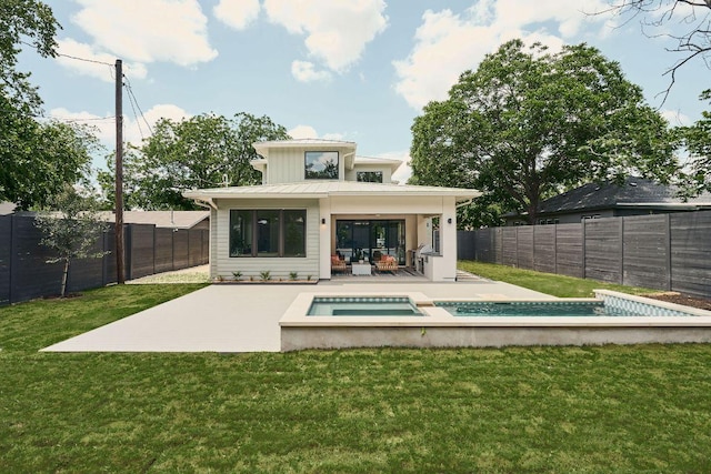 7809 Hardy Dr, Austin, TX 78757 - rear view of house featuring a standing seam roof, a fenced backyard, an in-ground hot tub, and a patio area