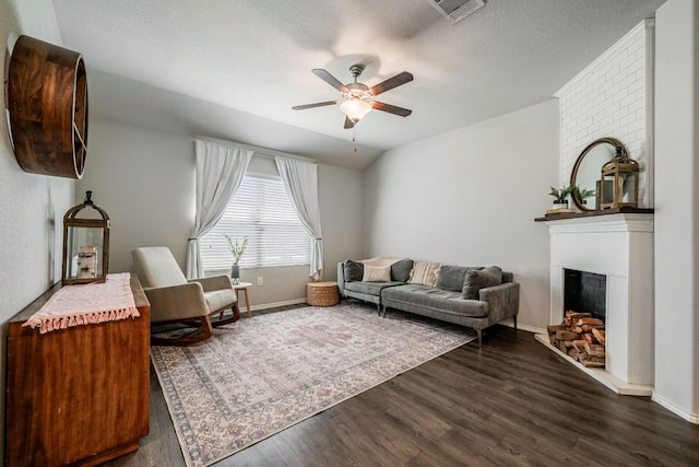 5817 Bell Tower Ln, Austin, TX 78747 - living room with a ceiling fan, dark wood-style flooring, a large fireplace, and baseboards