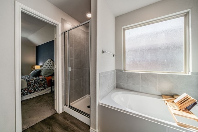 5817 Bell Tower Ln, Austin, TX 78747 - ensuite bathroom featuring a stall shower, a garden tub, and wood finished floors