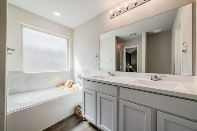 5817 Bell Tower Ln, Austin, TX 78747 - full bath featuring plenty of natural light, double vanity, wood finished floors, and a garden tub