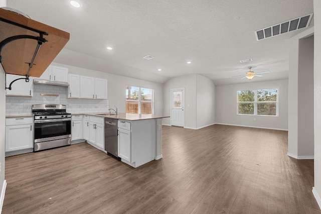 5817 Bell Tower Ln, Austin, TX 78747 - kitchen featuring stainless steel appliances, a peninsula, open floor plan, a sink, and baseboards