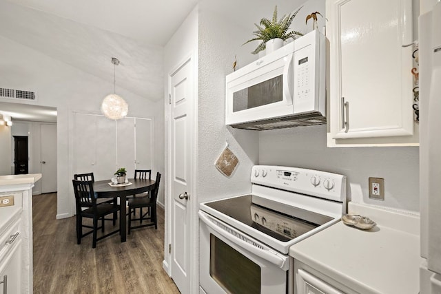 1601 Faro Dr Unit 303, Austin, TX 78741 - kitchen with white appliances, vaulted ceiling, wood finished floors, white cabinets, and hanging light fixtures