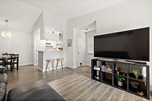 1601 Faro Dr Unit 303, Austin, TX 78741 - living room with wood finished floors, baseboards, a chandelier, and high vaulted ceiling