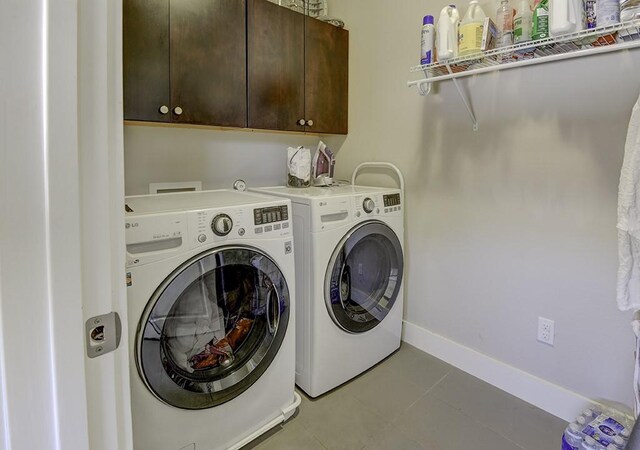 8200 SW Pkwy Unit 721, Austin, TX 78735 - washroom with washing machine and clothes dryer, cabinet space, light tile patterned floors, and baseboards