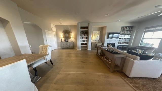 8200 SW Pkwy Unit 721, Austin, TX 78735 - living area featuring a fireplace, light wood-type flooring, built in features, and arched walkways