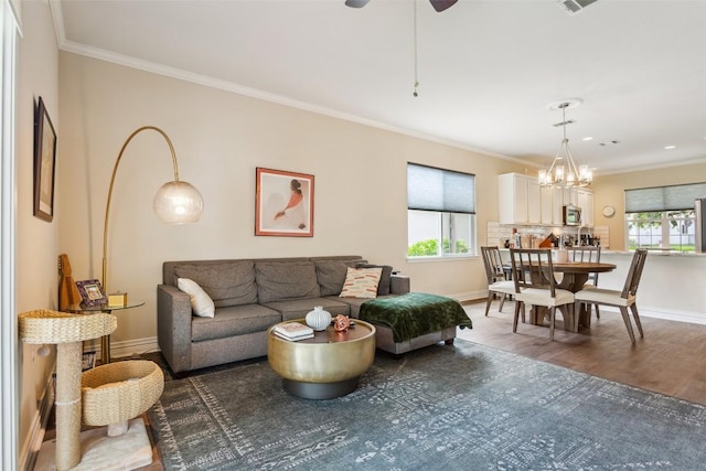 131 Nolan Dr, Georgetown, TX 78633 - living area featuring plenty of natural light, ornamental molding, wood finished floors, baseboards, and a chandelier