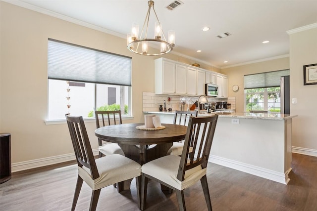 131 Nolan Dr, Georgetown, TX 78633 - dining room featuring wood finished floors, a chandelier, ornamental molding, and recessed lighting