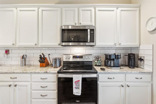 131 Nolan Dr, Georgetown, TX 78633 - kitchen featuring appliances with stainless steel finishes, white cabinets, backsplash, and light stone counters