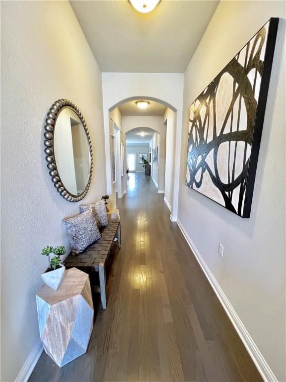 14925 Via Del Corso Dr, Austin, TX 78738 - corridor with arched walkways, wood finished floors, and baseboards