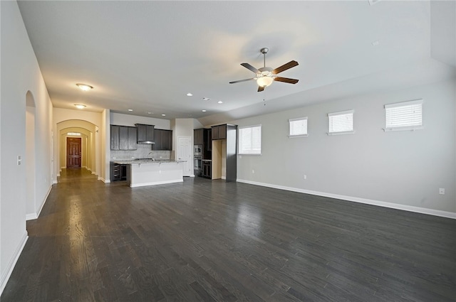 14925 Via Del Corso Dr, Austin, TX 78738 - unfurnished living room featuring ceiling fan, arched walkways, baseboards, dark wood-style floors, and recessed lighting