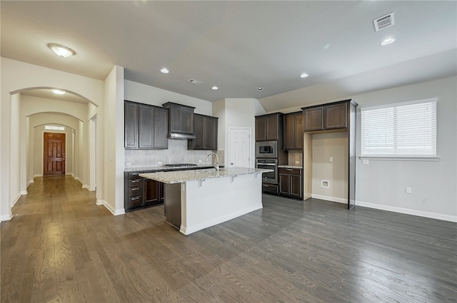 14925 Via Del Corso Dr, Austin, TX 78738 - kitchen with appliances with stainless steel finishes, dark brown cabinets, arched walkways, dark wood-style flooring, and recessed lighting