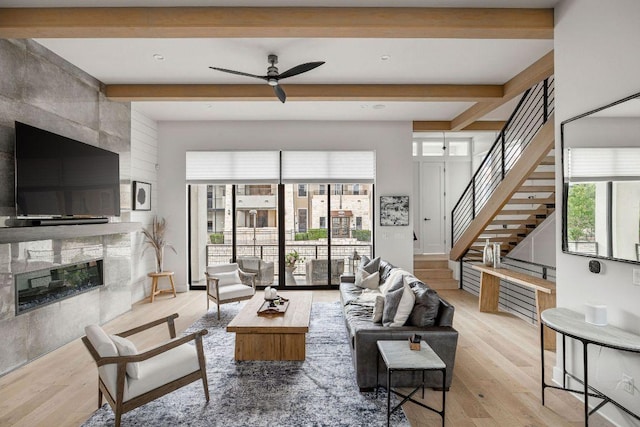 13410 Galleria Cir, Austin, TX 78738 - living room with beamed ceiling, ceiling fan, a high end fireplace, wood finished floors, and stairs