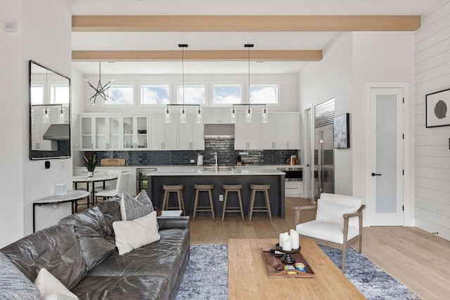 13410 Galleria Cir, Austin, TX 78738 - living area featuring beam ceiling, light wood-style floors, healthy amount of natural light, wine cooler, and wooden walls