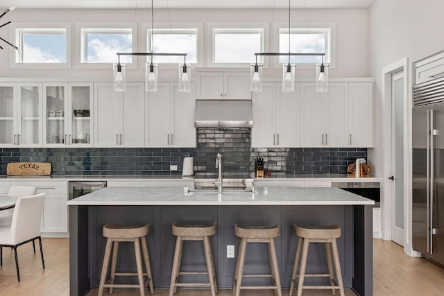 13410 Galleria Cir, Austin, TX 78738 - kitchen with exhaust hood, tasteful backsplash, and light wood-style floors