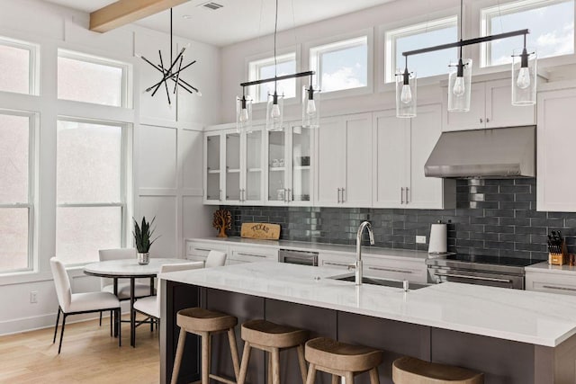 13410 Galleria Cir, Austin, TX 78738 - kitchen with under cabinet range hood, a sink, stainless steel electric stove, backsplash, and beam ceiling