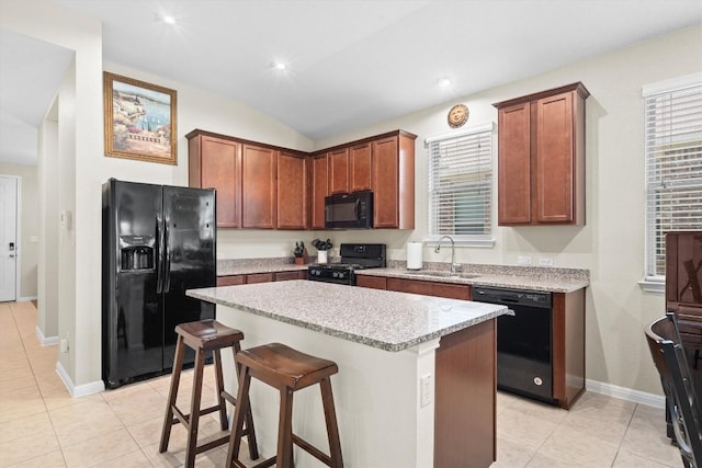 1608 Torre St, Leander, TX 78641 - kitchen with black appliances, a center island, a kitchen bar, light stone countertops, and light tile patterned floors