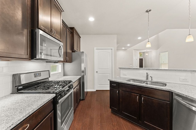7709 Menchaca Rd Unit 5, Austin, TX 78745 - kitchen featuring appliances with stainless steel finishes, dark brown cabinetry, tasteful backsplash, dark wood-style flooring, and decorative light fixtures