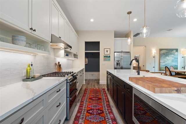 4605 Englewood Dr Unit A, Austin, TX 78745 - kitchen with stainless steel appliances, under cabinet range hood, tasteful backsplash, decorative light fixtures, and open shelves