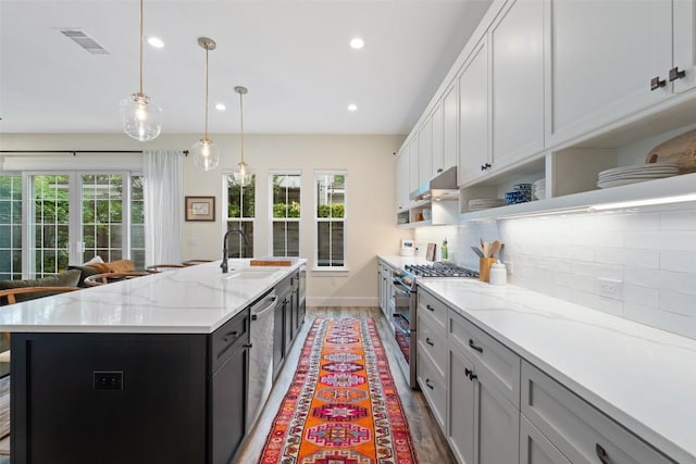 4605 Englewood Dr Unit A, Austin, TX 78745 - kitchen with appliances with stainless steel finishes, wood finished floors, plenty of natural light, a center island with sink, and recessed lighting