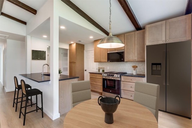 8409 Kimble Cv, Austin, TX 78757 - kitchen with stainless steel appliances, dark countertops, tasteful backsplash, a breakfast bar, and recessed lighting