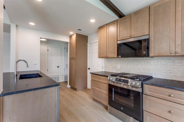 8409 Kimble Cv, Austin, TX 78757 - kitchen with stainless steel range with gas stovetop, a sink, light brown cabinetry, light wood-type flooring, and recessed lighting