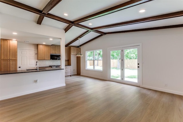 8409 Kimble Cv, Austin, TX 78757 - kitchen with dark countertops, stainless steel microwave, light wood-type flooring, tasteful backsplash, and recessed lighting