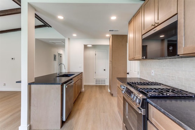 8409 Kimble Cv, Austin, TX 78757 - kitchen with stainless steel appliances, a sink, light wood-style floors, backsplash, and baseboards