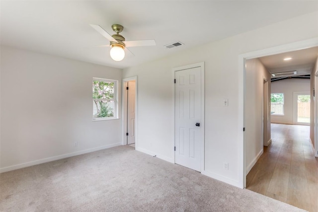 8409 Kimble Cv, Austin, TX 78757 - unfurnished bedroom with multiple windows, baseboards, light carpet, and a ceiling fan