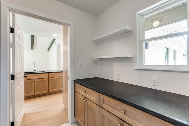 8409 Kimble Cv, Austin, TX 78757 - kitchen with a sink, open shelves, brown cabinetry, and light wood finished floors
