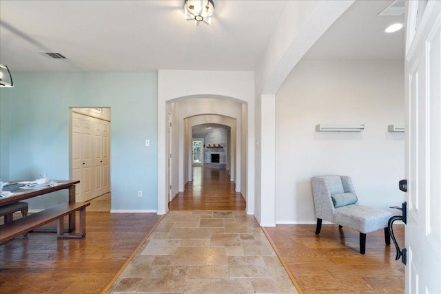 1509 Foster Dr, Cedar Park, TX 78613 - hallway with arched walkways, baseboards, and light stone finish floors