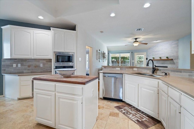 1509 Foster Dr, Cedar Park, TX 78613 - kitchen with stainless steel appliances, a sink, stone tile floors, backsplash, and a ceiling fan