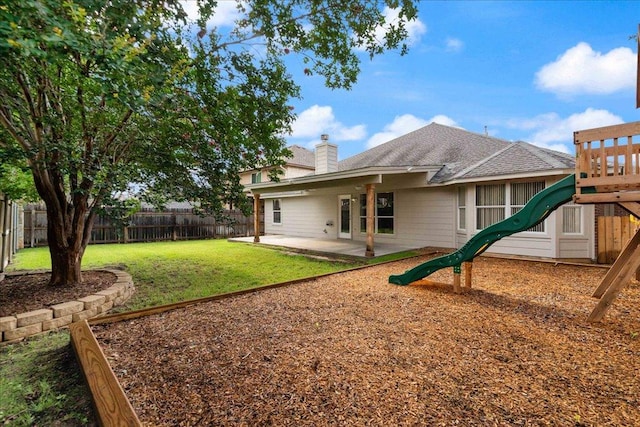1509 Foster Dr, Cedar Park, TX 78613 - rear view of property with a playground, a chimney, a patio area, a fenced backyard, and a shingled roof