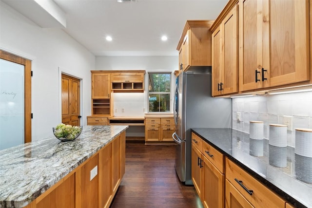 321 Hannah Dr, Dripping Springs, TX 78620 - kitchen with dark wood-style flooring, dark stone countertops, recessed lighting, backsplash, and freestanding refrigerator