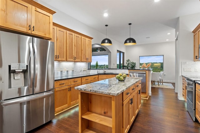 321 Hannah Dr, Dripping Springs, TX 78620 - kitchen with stainless steel appliances, decorative backsplash, dark wood-style floors, a kitchen island, and recessed lighting