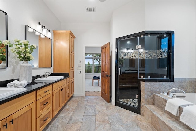 321 Hannah Dr, Dripping Springs, TX 78620 - full bath featuring double vanity, a bath, a stall shower, and baseboards