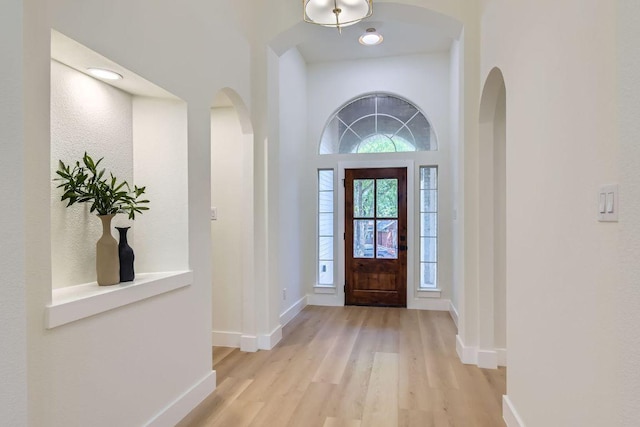 9124 Fainwood Ln, Austin, TX 78749 - foyer featuring light wood finished floors, arched walkways, and baseboards