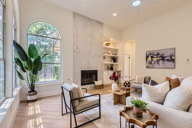 9124 Fainwood Ln, Austin, TX 78749 - living area with a ceiling fan, arched walkways, a fireplace, light wood finished floors, and recessed lighting