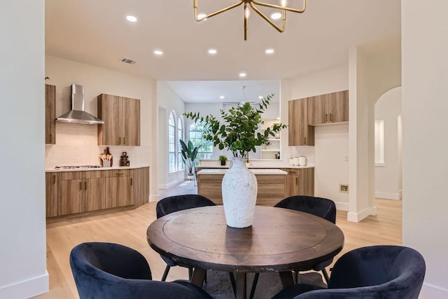 9124 Fainwood Ln, Austin, TX 78749 - dining space featuring a chandelier, light wood finished floors, arched walkways, recessed lighting, and baseboards