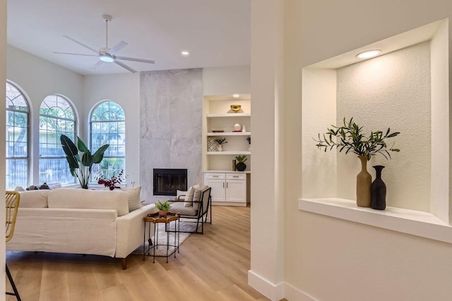 9124 Fainwood Ln, Austin, TX 78749 - living area featuring a ceiling fan, light wood-style floors, a tiled fireplace, recessed lighting, and baseboards