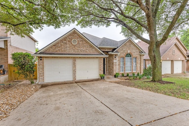 13532 Utah Flats Dr, Austin, TX 78727 - traditional home featuring driveway, brick siding, an attached garage, and roof with shingles
