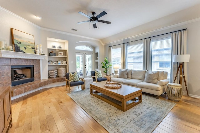 13532 Utah Flats Dr, Austin, TX 78727 - living area with ornamental molding, french doors, a ceiling fan, light wood-style floors, and a fireplace