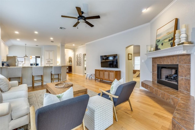 13532 Utah Flats Dr, Austin, TX 78727 - living area with arched walkways, a ceiling fan, crown molding, light wood-type flooring, and plenty of natural light
