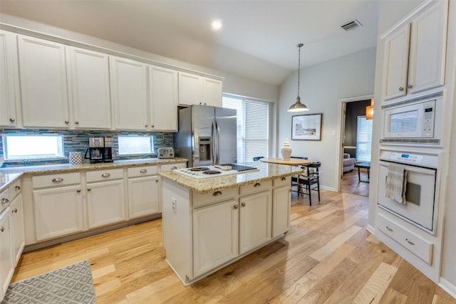 13532 Utah Flats Dr, Austin, TX 78727 - kitchen with white appliances, lofted ceiling, tasteful backsplash, a kitchen island, and hanging light fixtures