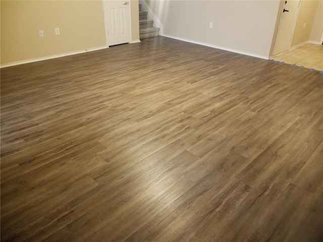 1516 Anise Dr, Austin, TX 78741 - unfurnished room with baseboards, stairway, and dark wood-style floors