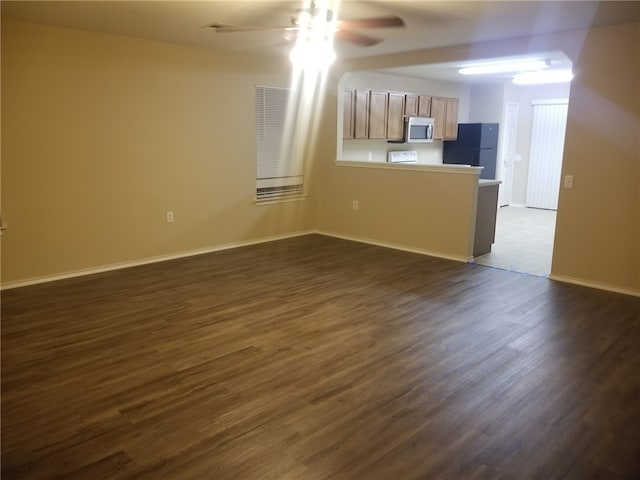 1516 Anise Dr, Austin, TX 78741 - unfurnished living room with a ceiling fan, dark wood-type flooring, and baseboards