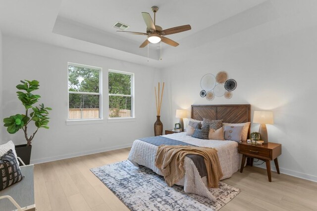 2705 Sage Ranch Dr Unit 2, Leander, TX 78641 - bedroom with light wood-type flooring, a raised ceiling, baseboards, and ceiling fan