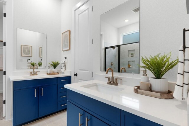 2705 Sage Ranch Dr Unit 2, Leander, TX 78641 - full bathroom featuring two vanities, a shower stall, and tile patterned floors