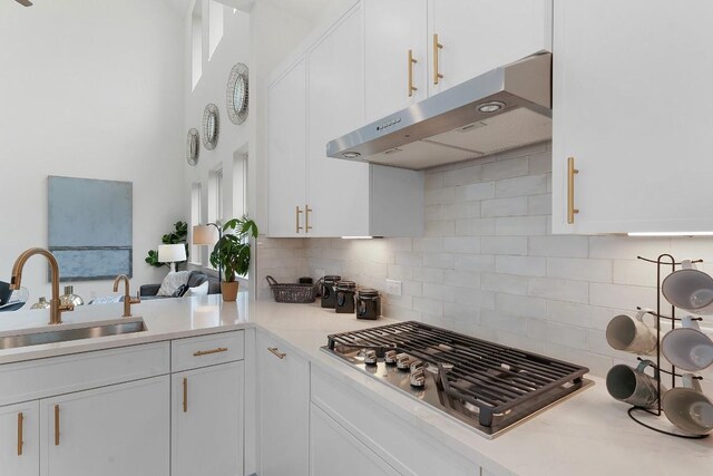2705 Sage Ranch Dr Unit 2, Leander, TX 78641 - kitchen with under cabinet range hood, stainless steel gas stovetop, a sink, white cabinetry, and light countertops