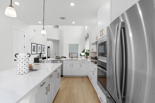 2705 Sage Ranch Dr Unit 2, Leander, TX 78641 - kitchen featuring stainless steel appliances, a sink, white cabinetry, recessed lighting, and light wood-style flooring